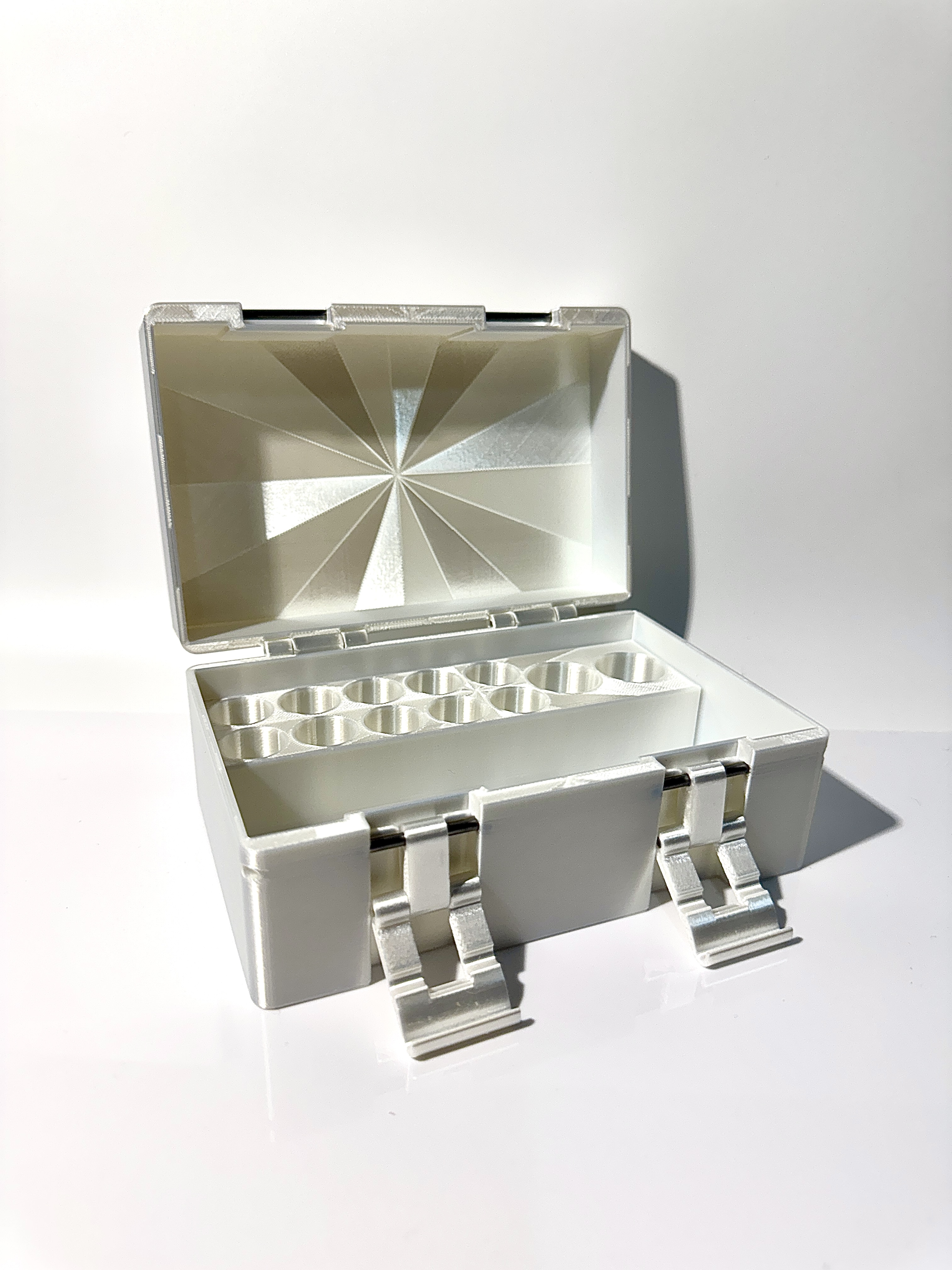 White pearl vial box fully open, showing starburst lid interior and vial rows